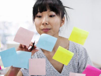 Young woman writing on sticky notes