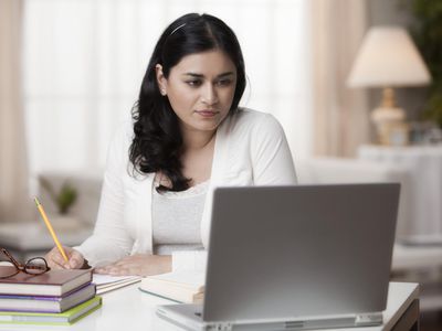 Mixed race woman studying on laptop