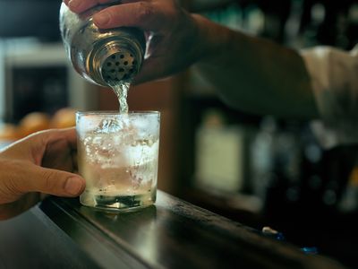 Close-up of bartender hand pouring cocktail