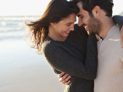 man and woman hugging and smiling on a beach
