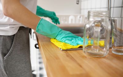 Midsection Of Woman Cleaning Kitchen Counter
