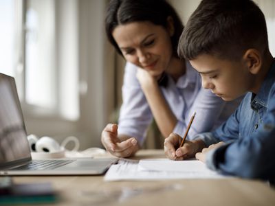 Mother helping teenager with homework