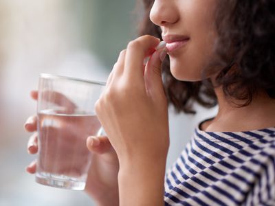 Cropped shot of an unrecognizable teenage girl drinking medication
