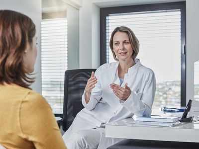 Female doctor speaking with female patient in office
