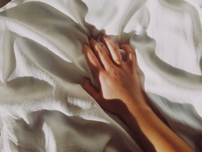 woman's hand on bed