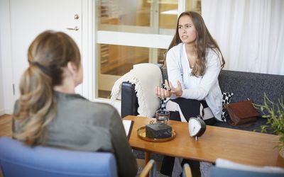 Teenage girl discussing problems with female therapist at community center