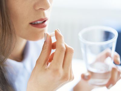 Woman taking pill with a glass of water