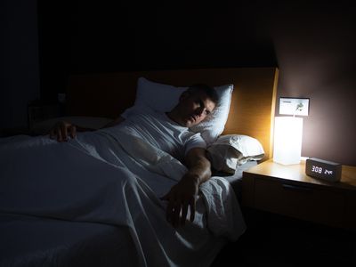 Man awake staring at alarm clock