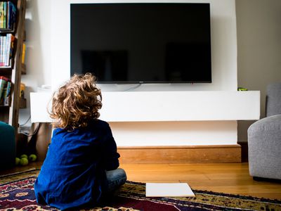 A kid in living room watching tv
