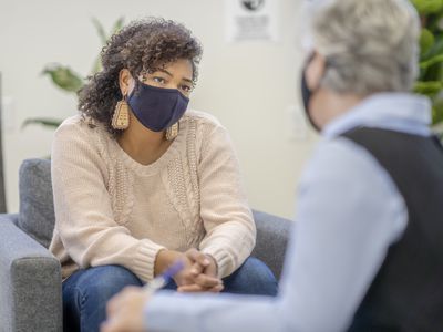Patient and counsellor wearing face masks during a therapy session during the COVID-19 pandemic.