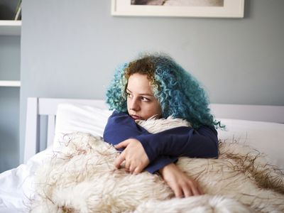 Young woman looking sad depressed and alone in bed