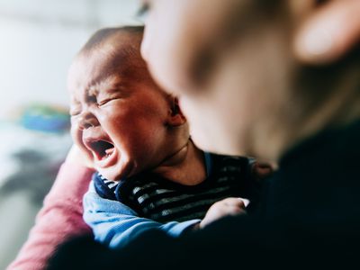 baby crying on parent's chest