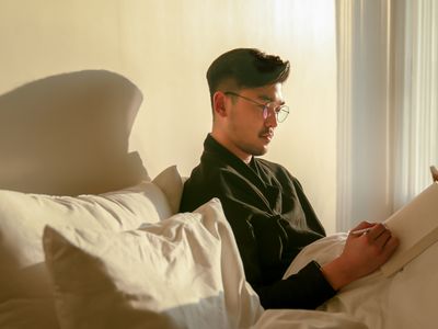 Man with notebook on bed in hotel room