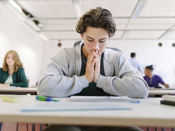 A worried high school student looking at his test paper before starting during an exam