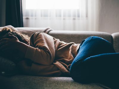 Woman lying on the couch depressed.