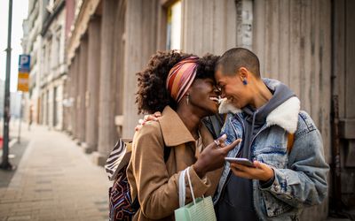 Close up of a young female couple shopping and exploring the city while navigating using their smart phone