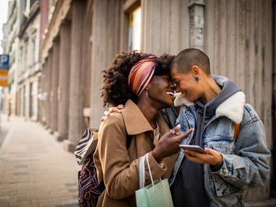 Close up of a young female couple shopping and exploring the city while navigating using their smart phone