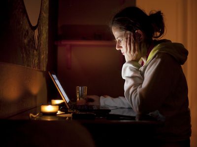 Woman looking at computer in dark room