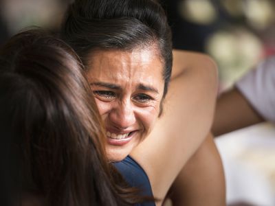 Hispanic women hugging and crying