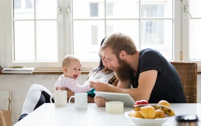 Young couple with baby sitting at table
