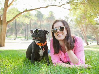 A woman and a dog wearing sunglasses