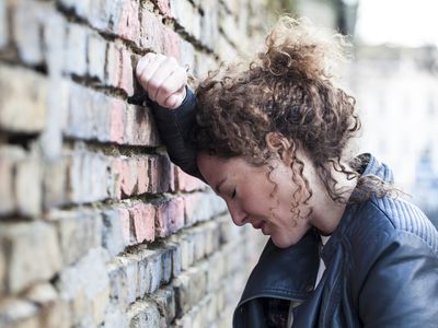 Woman leaning against brick wall