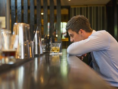 Lonely Hispanic businessman sitting at bar