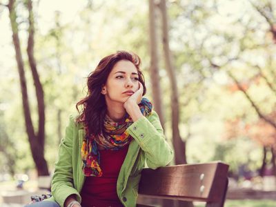 Unhappy woman sitting on a park bench