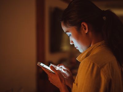Young lady using smartphone at home in the night