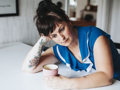 woman-looking-depressed-while-holding-a-cup-of-coffee