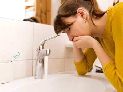 woman nauseous at sink