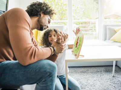 Father helping daughter learn reading the clock