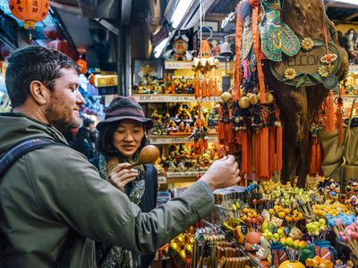 man and woman looking at trinkets while traveling