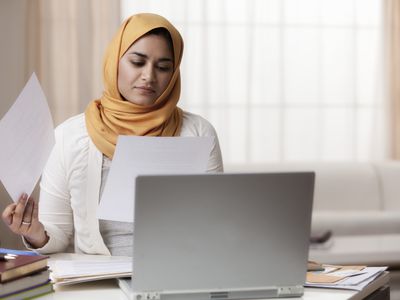 Mixed race woman in hijab looking at paperwork