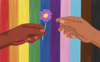 Hand extending a flower to another hand against a rainbow Pride flag