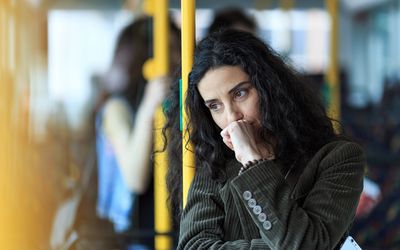 Pensive young woman traveling and holding smart phone