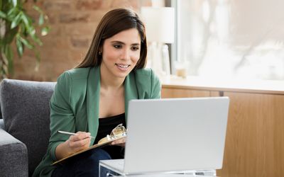 Mental health professional uses laptop to see clients 
