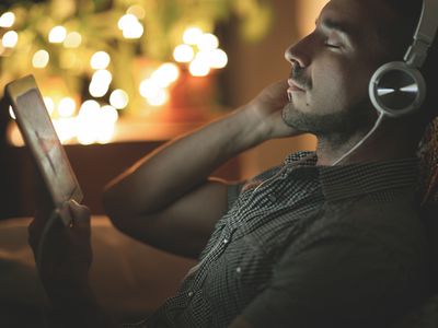Relaxed man listening to music at home at night