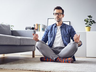 Relaxed man meditating at home