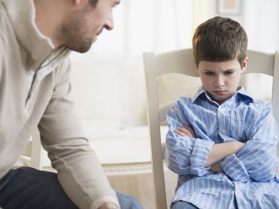 Father looking at upset young boy