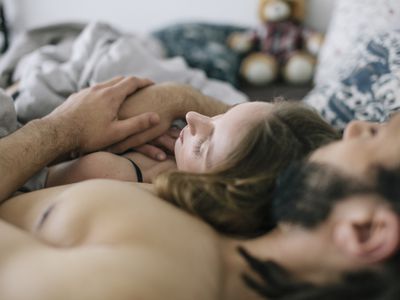 Man and woman sleeping together in bed, early morning