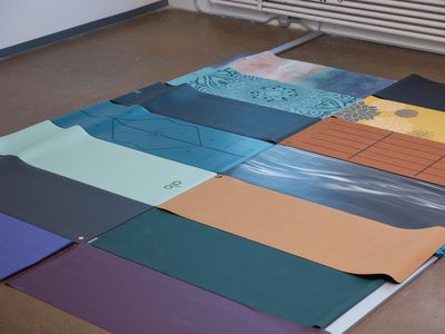 An array of yoga mats placed on wood flooring
